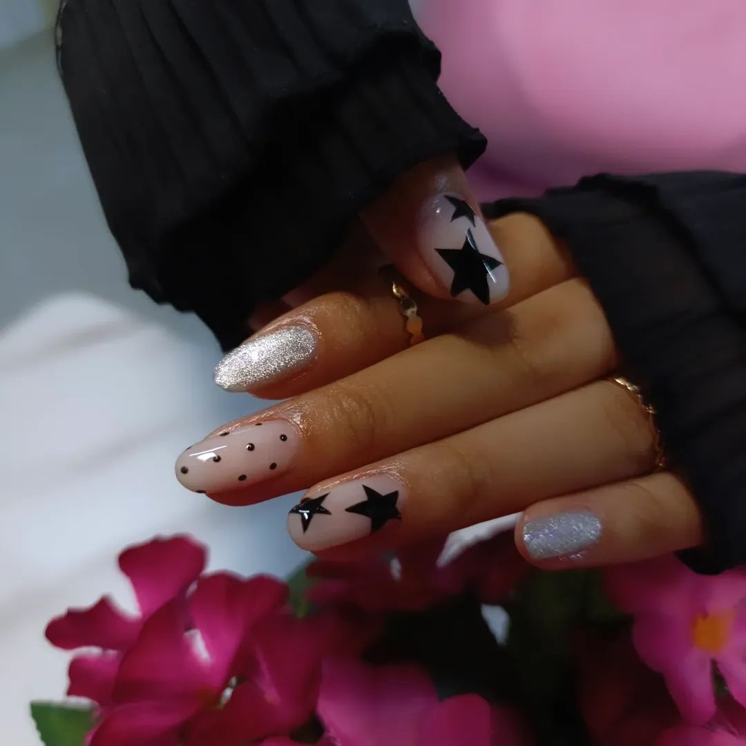Uñas almendra con estrellas negras y glitter